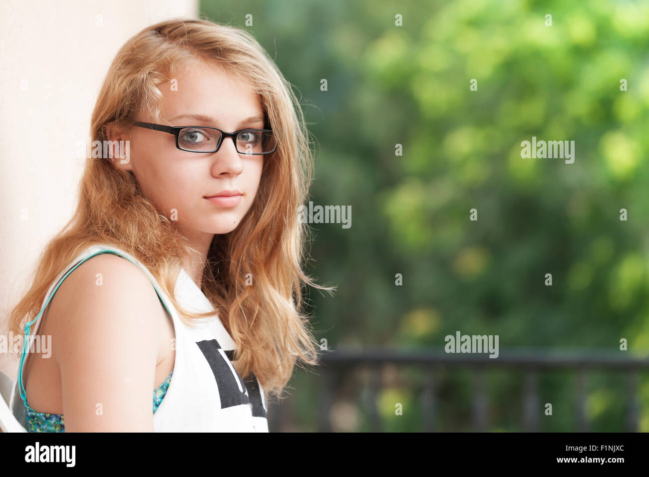 Schöne blonde kaukasische Teenager-Mädchen sitzt auf dem Balkon, outdoor-Sommer-Porträt Stockfoto