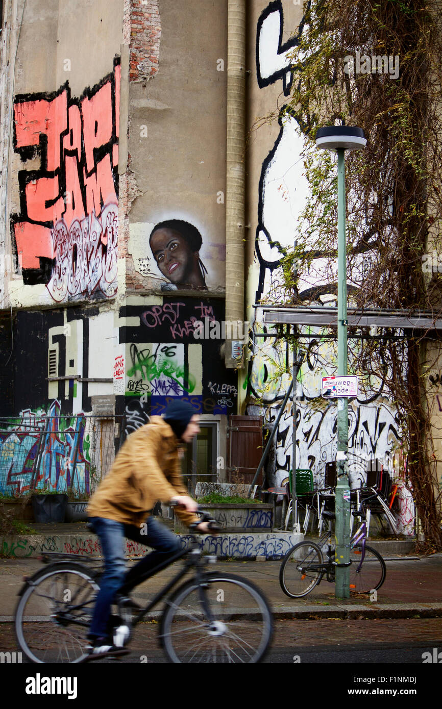 Europa; Deutschland; Berlin; Graffiti; Street-Art; Straße; Aufbau; Haus; Nachbarschaft; Junge; Mann; Fahrrad; Radfahrer; Straße Stockfoto