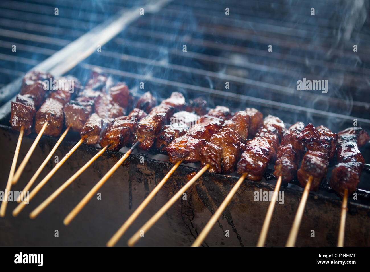 Abenteuerliche Kochen mit Satay Grillen im Freien auf einem Holzkohle Grill mit Rauch ausgelöst Stockfoto