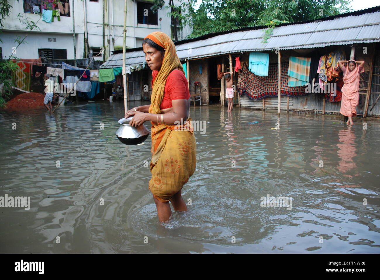 Eine Frau ging zur anderen Haus kochen ihr Essen unter Schmutzwasser überflutet. Das Hochwasser tritt die Häuser in der Sylhet Stadt wegen starken Dauerregen, es gibt Tausende von gestrandeten Menschen, die auf verschmutztes Wasser erhöht menschliches Leid in den Hochwassergebieten in Sylhet Stadt. (Foto von MD. Akhlas Uddin / Pacific Press) Stockfoto