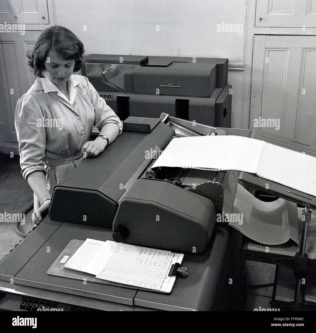 Historische, 1950er Jahre, Sekretärin oder Konten Kaufmann/-Frau im arbeiten mit einer IBM Tabellieren, eine Buchhaltung oder Daten Aufnahmemaschine und Drucker. Stockfoto