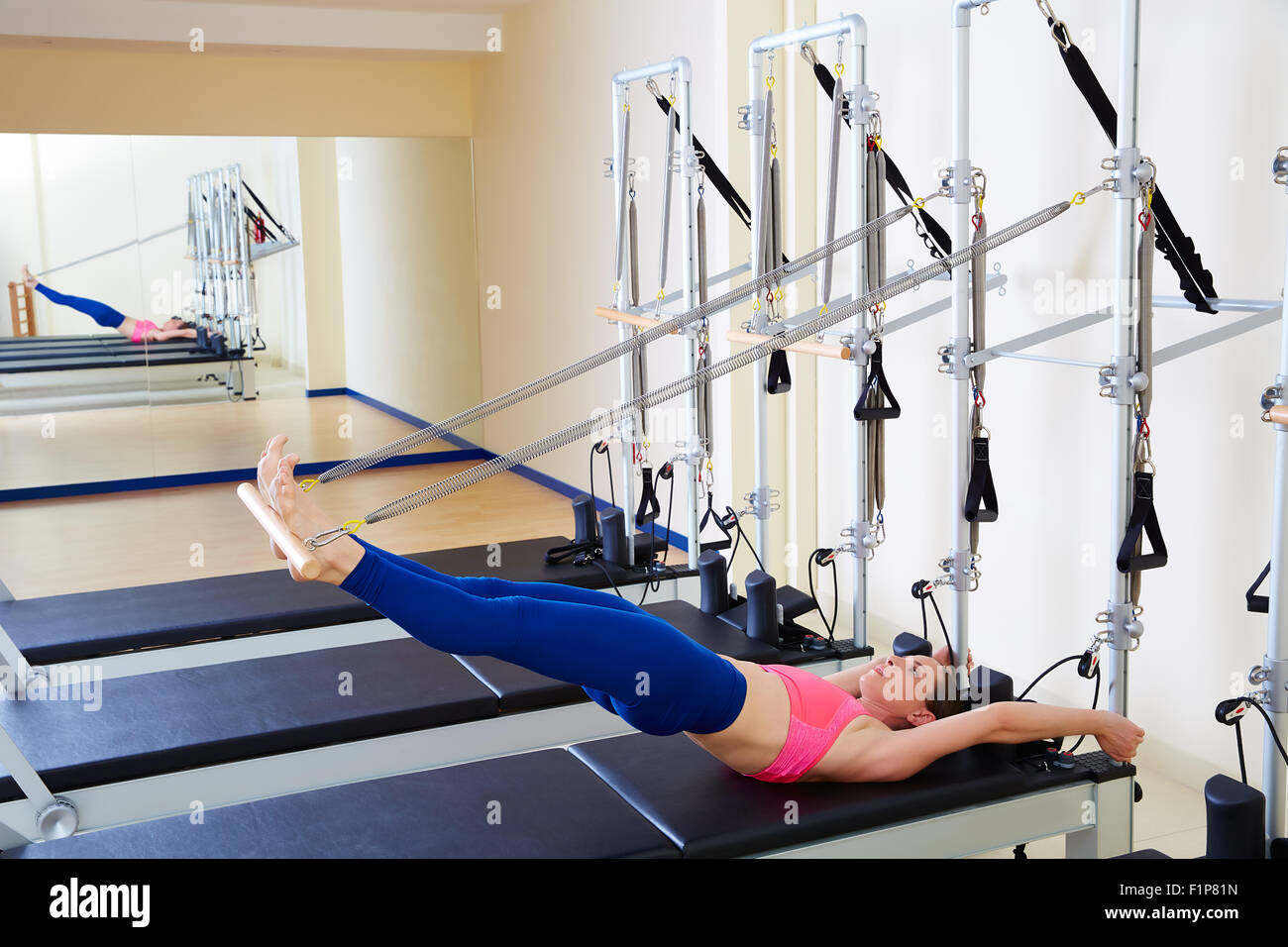 Pilates Reformer Frau lange Wirbelsäule ausüben, trainieren Sie im Fitness-Studio indoor Stockfoto