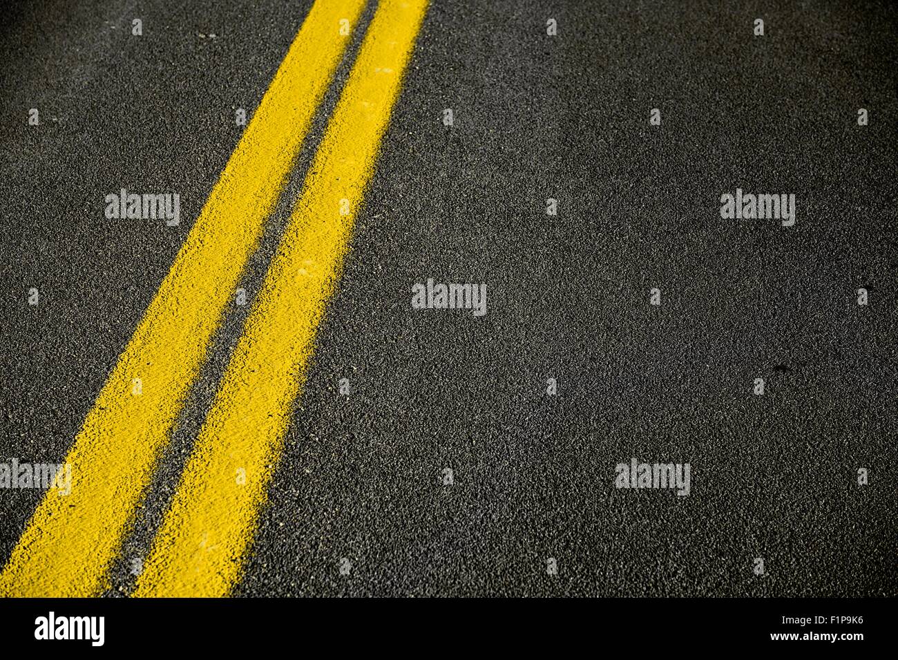 Straße Bürgersteig Hintergrund - schwarze Fahrbahn mit gelbe Doppellinie. Reise- und Transport-Hintergrunddesign. Stockfoto