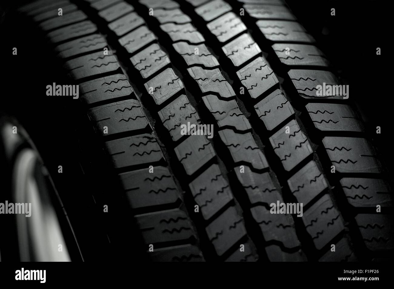 Autoreifen auf schwarzem Hintergrund. Pkw-Reifen in der Dunkelheit - Spot-Licht Stockfoto