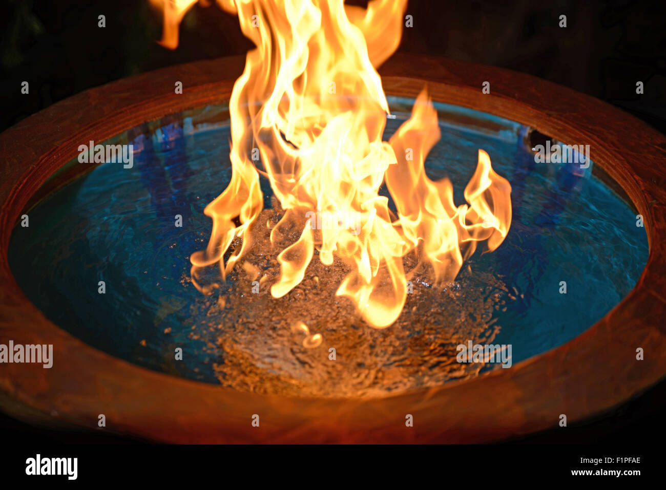 Erdgas sprudelte durch eine Trommel von Wasser erzeugt eine surreale Flamme darüber Stockfoto