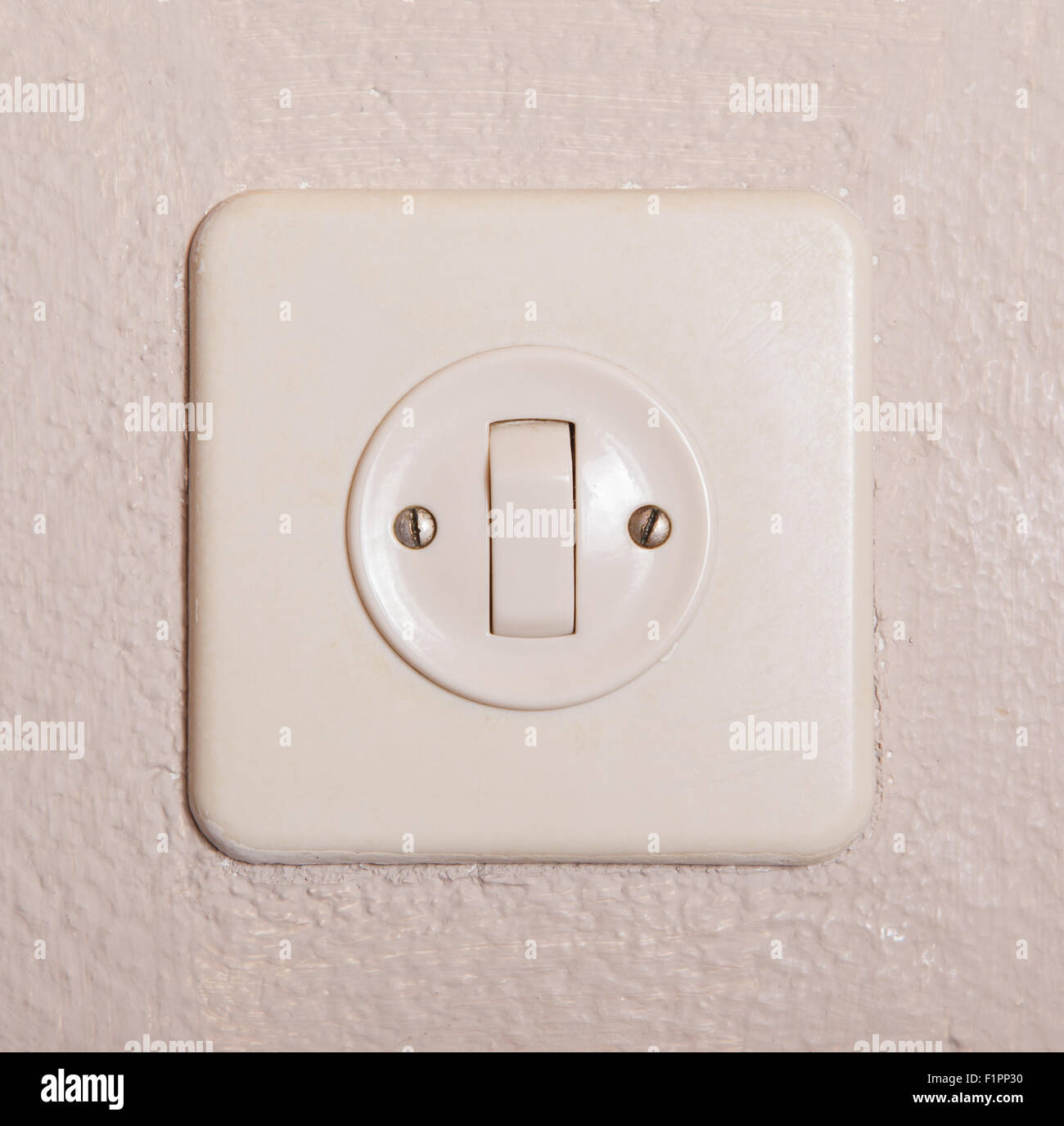 Drücken Sie Turn on/off elektrischen Schalter, alte verputzte Wand Stockfoto