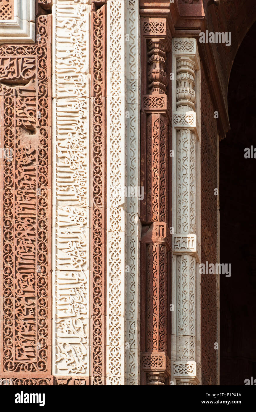 Delhi, Indien. Qutub Minar Komplex. Geschnitzte Einschreibungen in rotem Sandstein und Marmor auf dem Alai-Darwaza Tor in Naskh Schrift. Stockfoto