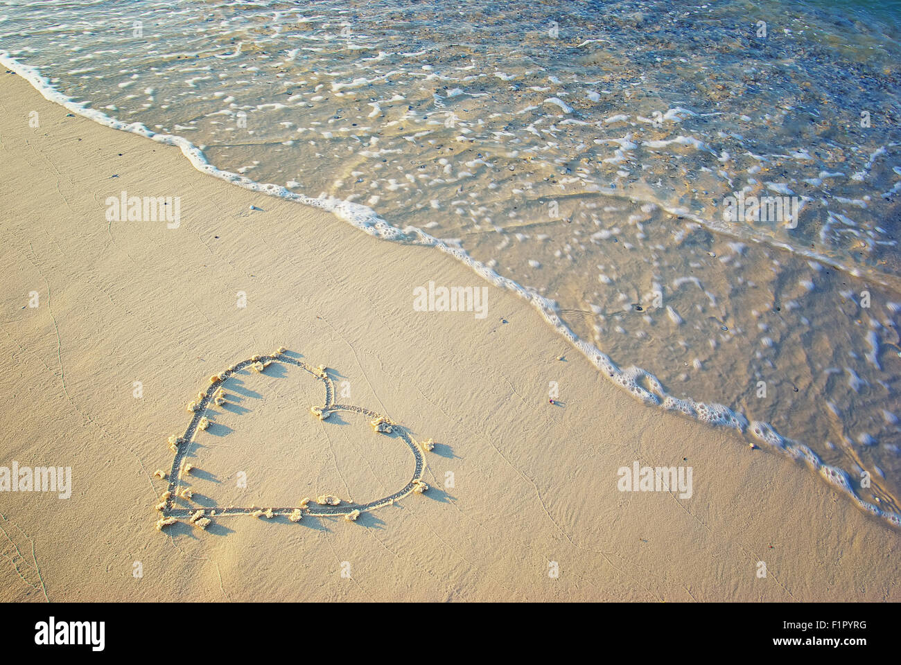 Herzen in den Sand gezeichnet. Strand Hintergrund. Ansicht von oben Stockfoto