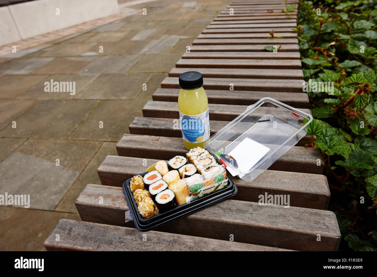 Supermarkt gekauft, Sushi und trinken auf einer Parkbank Birmingham UK Stockfoto