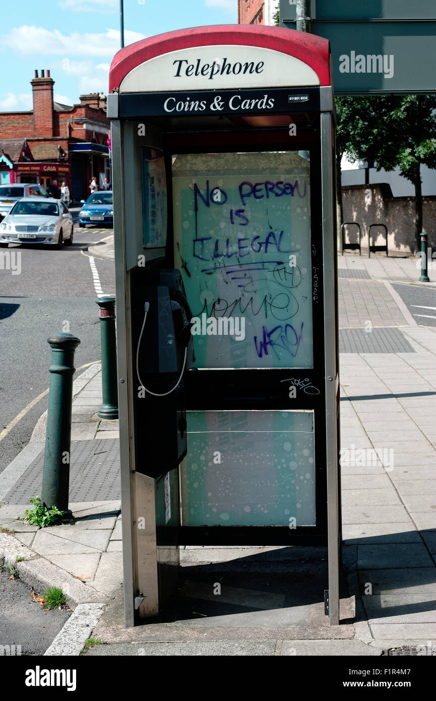 Graffiti an einer Telefonzelle gegen den Begriff "Illegale Einwanderer" sagen, niemand ist illegal. Stockfoto