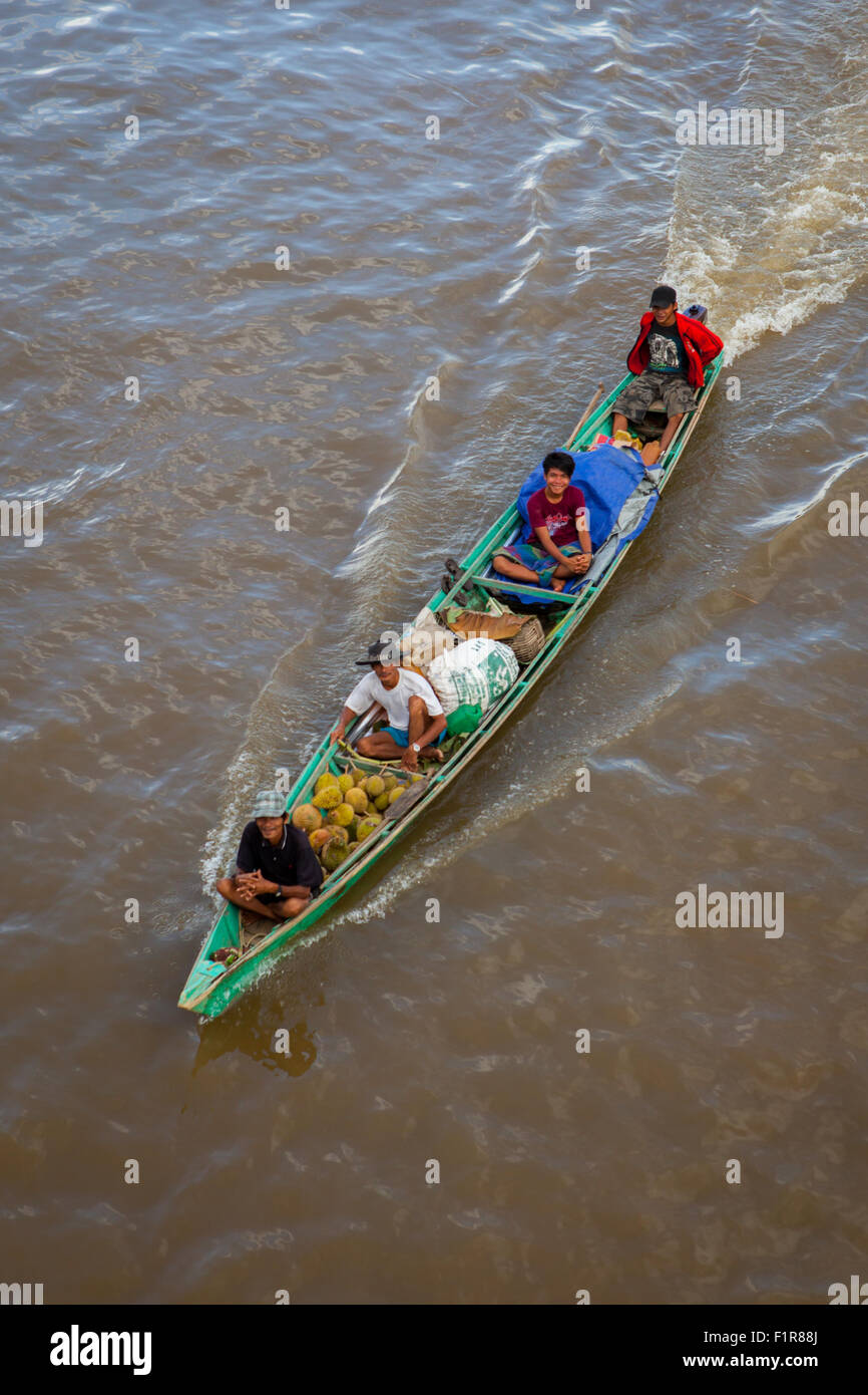 Menschen, die mit einem motorisierten Holzboot auf dem Kapuas-Fluss fahren, von einer Brücke aus gesehen in Putussibau, Kapuas Hulu, West Kalimantan, Indonesien. Stockfoto