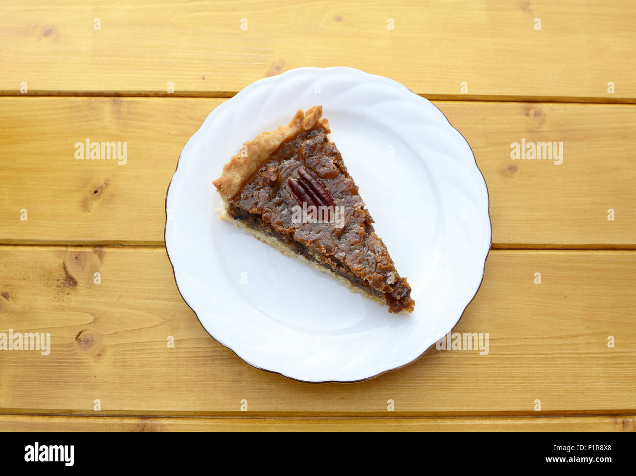 Teil des traditionellen Pecannusskuchen auf einem weißen Teller auf einem Holztisch Stockfoto