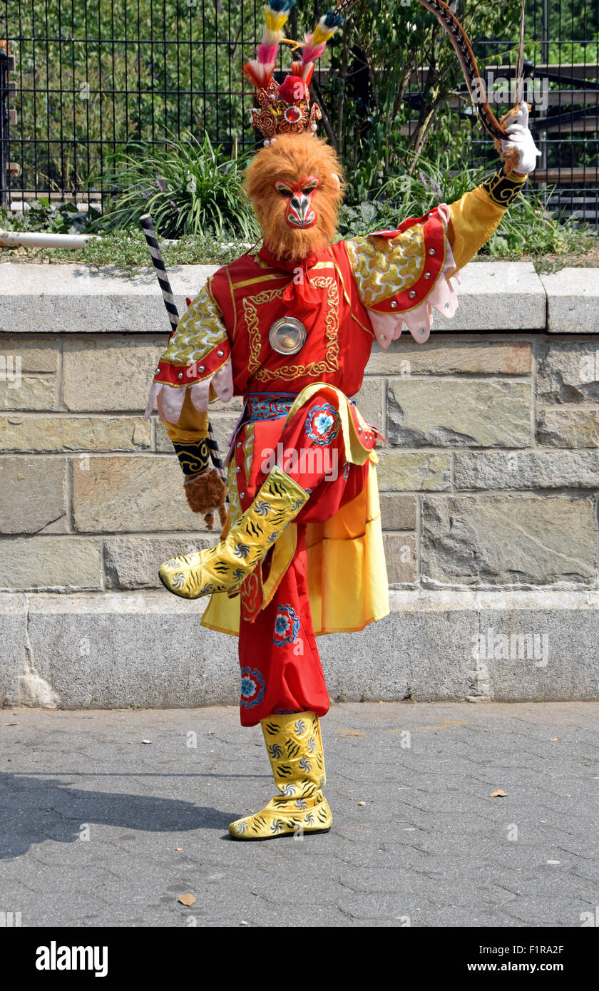 Foto eines asiatischen Straßenmusikers in einem bunten Simian gekleidet Kostümentanz für Spenden im Union Square Park in New York City Stockfoto