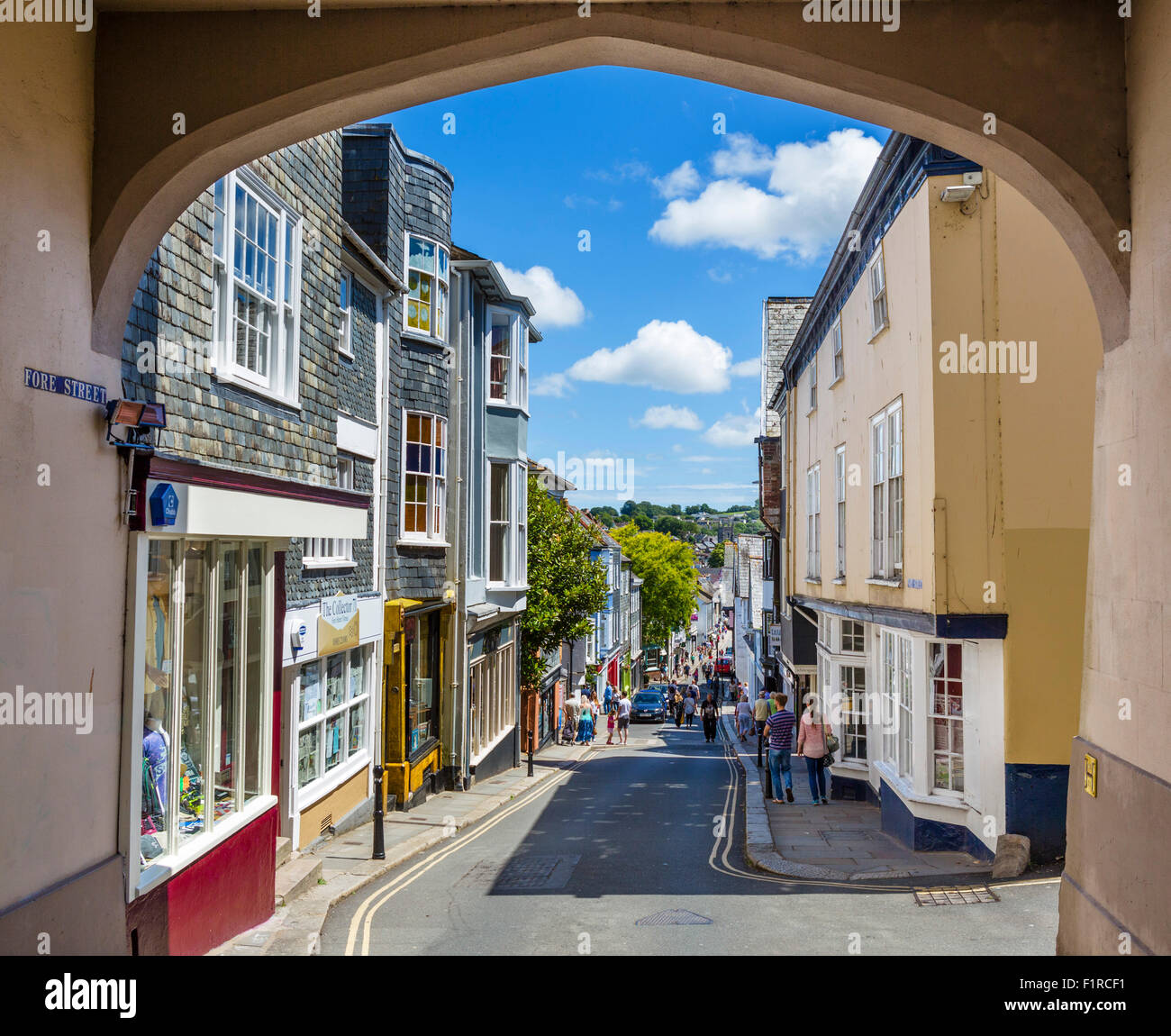 Geschäfte auf Vorderstraße in der Innenstadt von High Street durch Ostgatter betrachtet Bogen, Totnes, Devon, England, UK Stockfoto