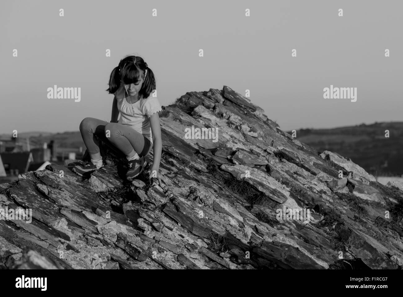 Hübsches junges Mädchen über eine Felswand klettern Stockfoto