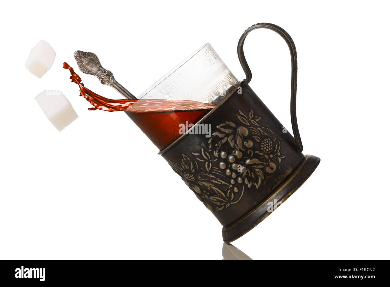 Tee-Splash aus Glas in Vintage Glashalter (Podstakannik). Konzeptbild Stockfoto