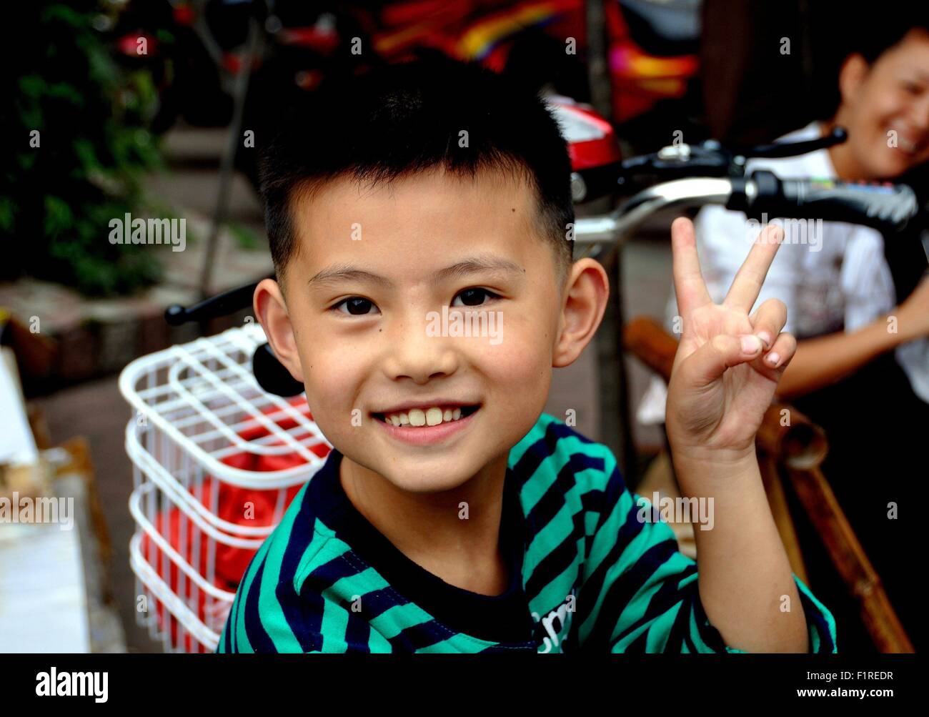 Pengzhou, China: Lächelnde Knabe gibt das traditionelle Symbol "V" mit seinen Fingern Stockfoto