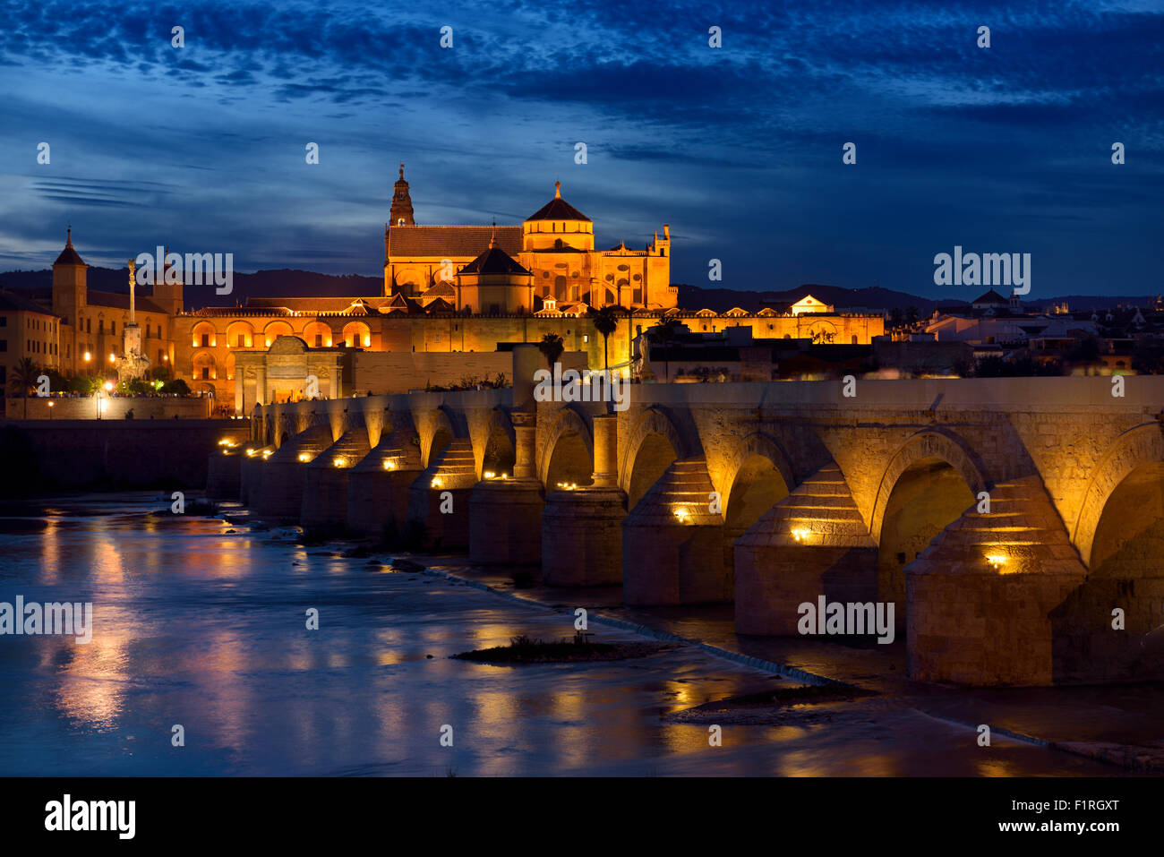 Nachtbeleuchtung auf römische Brücke über den Guadalquivir Fluss mit Bischofspalast und die Kathedrale von Cordoba Stockfoto