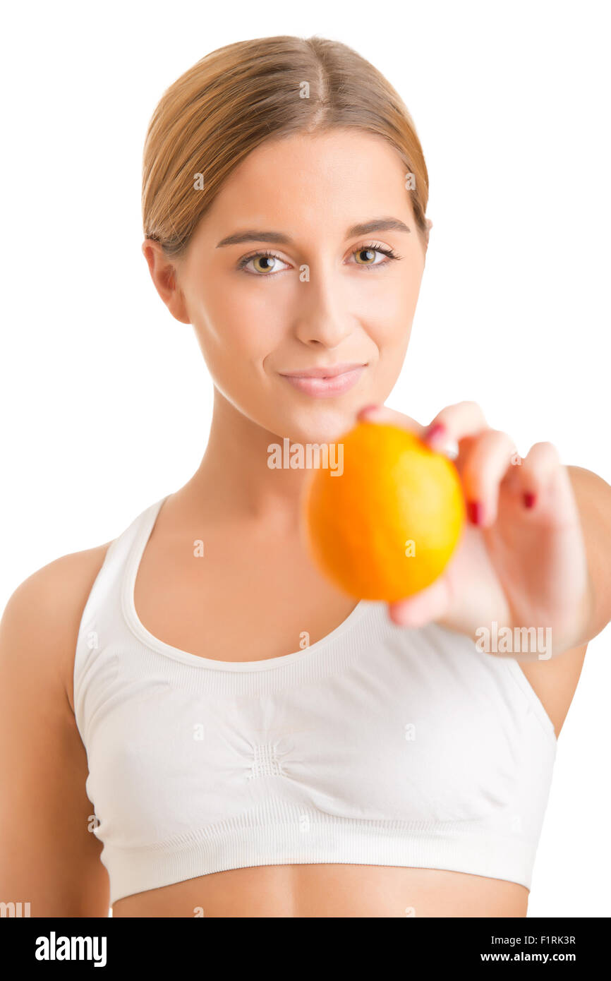 Fit Frau hält eine Orange in einem weißen Hintergrund Stockfoto