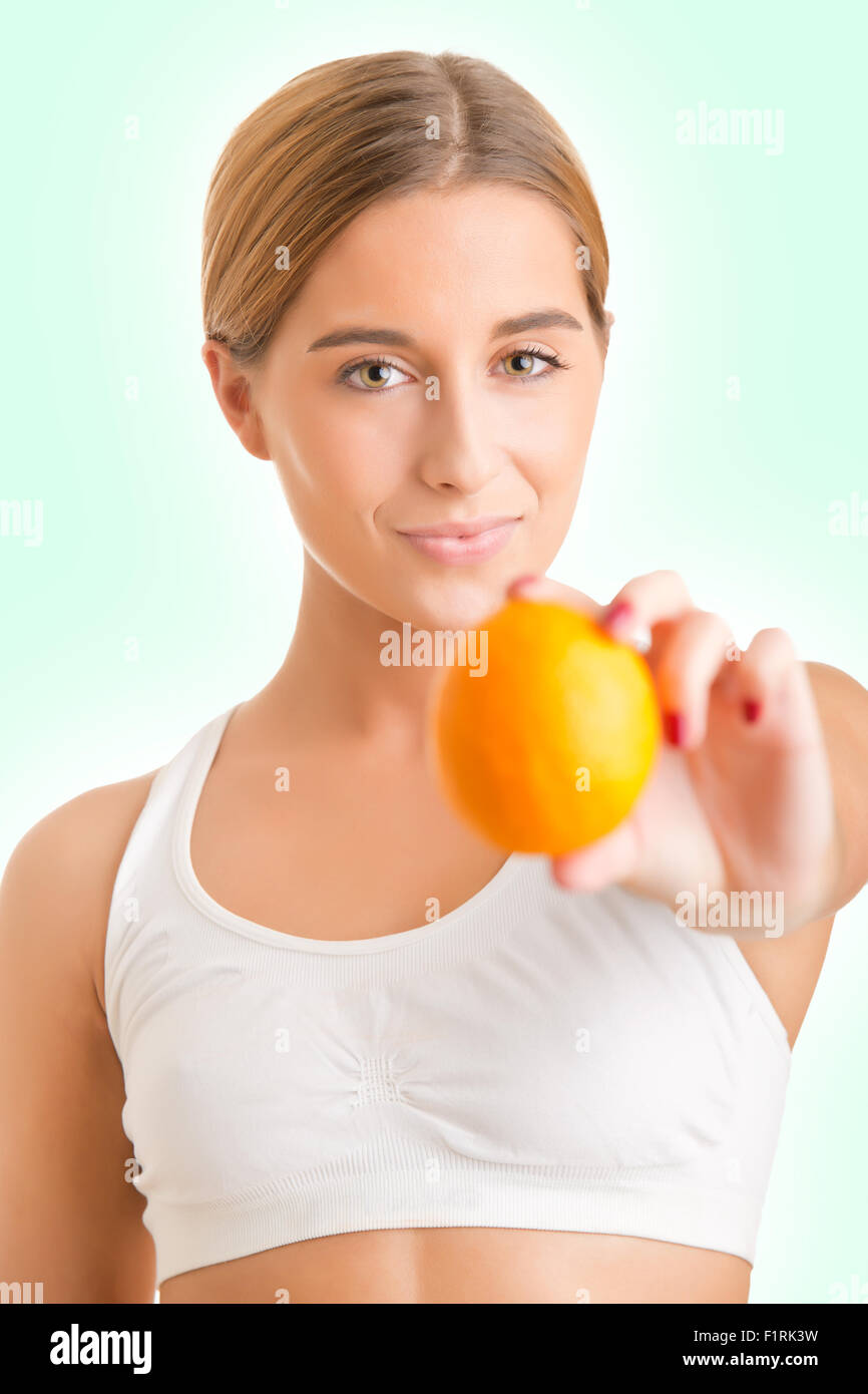 Fit Frau hält eine Orange in einem weißen Hintergrund Stockfoto