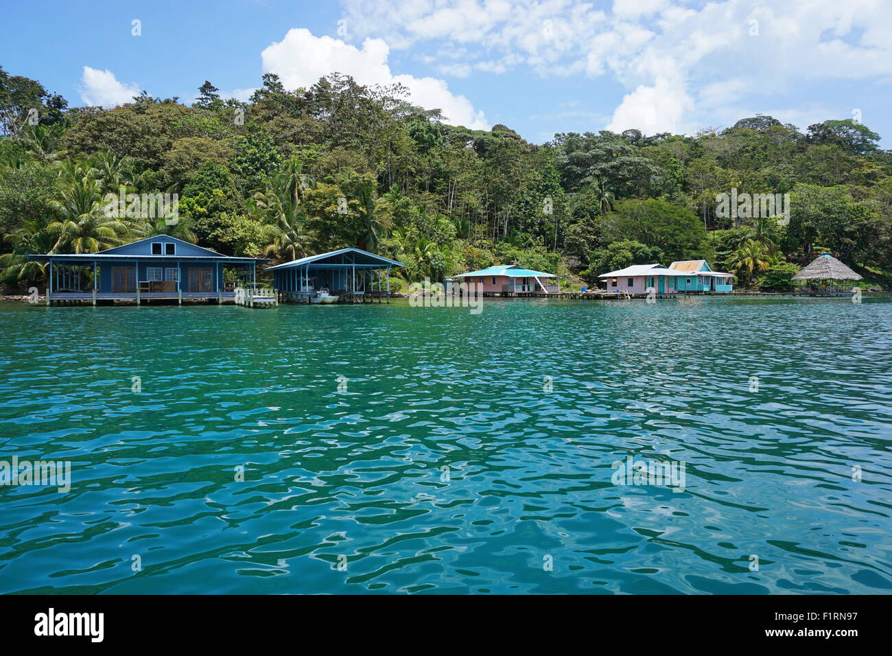 Üppige tropische Küste mit Häusern über dem Wasser, Bocas del Toro, karibische Küste von Panama in Mittelamerika Stockfoto
