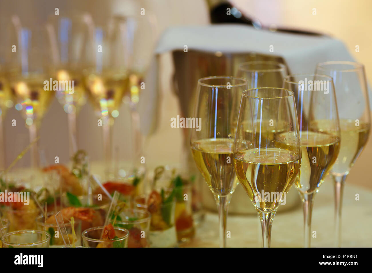 Nahaufnahme der festlich gedeckten Tafel mit Häppchen und Getränken. Konzentrieren Sie sich auf ein Glas Champagner. Hochzeit, Feier, fest-Konzept. Stockfoto