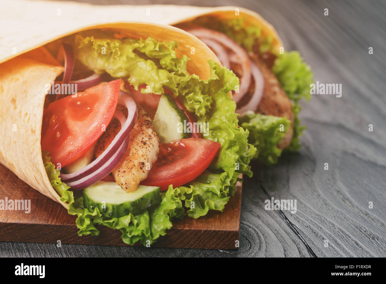 paar von frischen saftigen Tortilla wraps mit Huhn und Gemüse auf Tisch Stockfoto