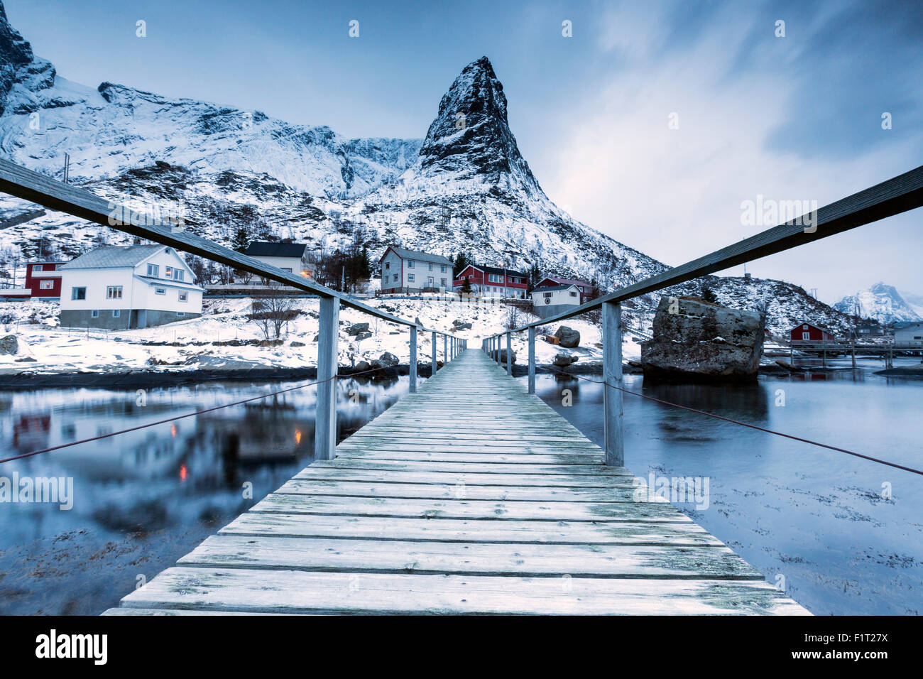 Eine Brücke über dem kalten Meer verbindet ein typisches Fischerdorf. Reine, Lofoten-Inseln, Nord-Norwegen, Skandinavien, Arktis Stockfoto