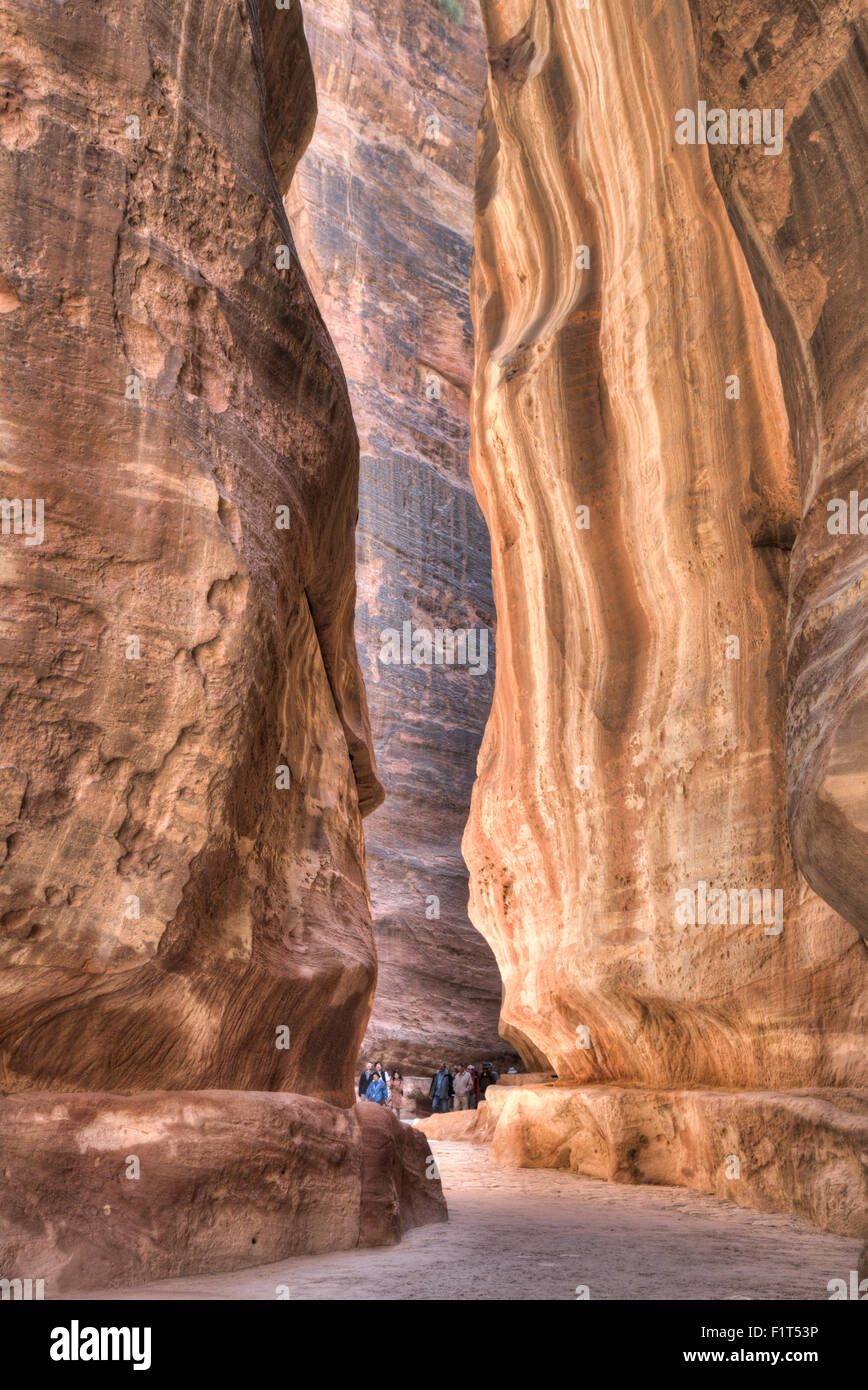 Touristen, die zu Fuß durch den Siq, Petra, naher UNESCO World Heritage Site, Jordanien, Osten Stockfoto