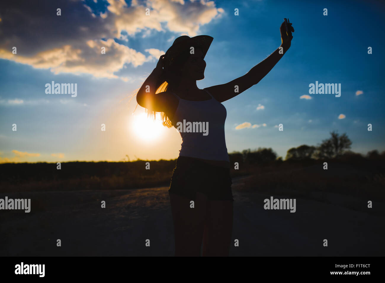 Frau in einem Cowboy-Hut fotografieren sich selbst blauen Himmel bei Stockfoto