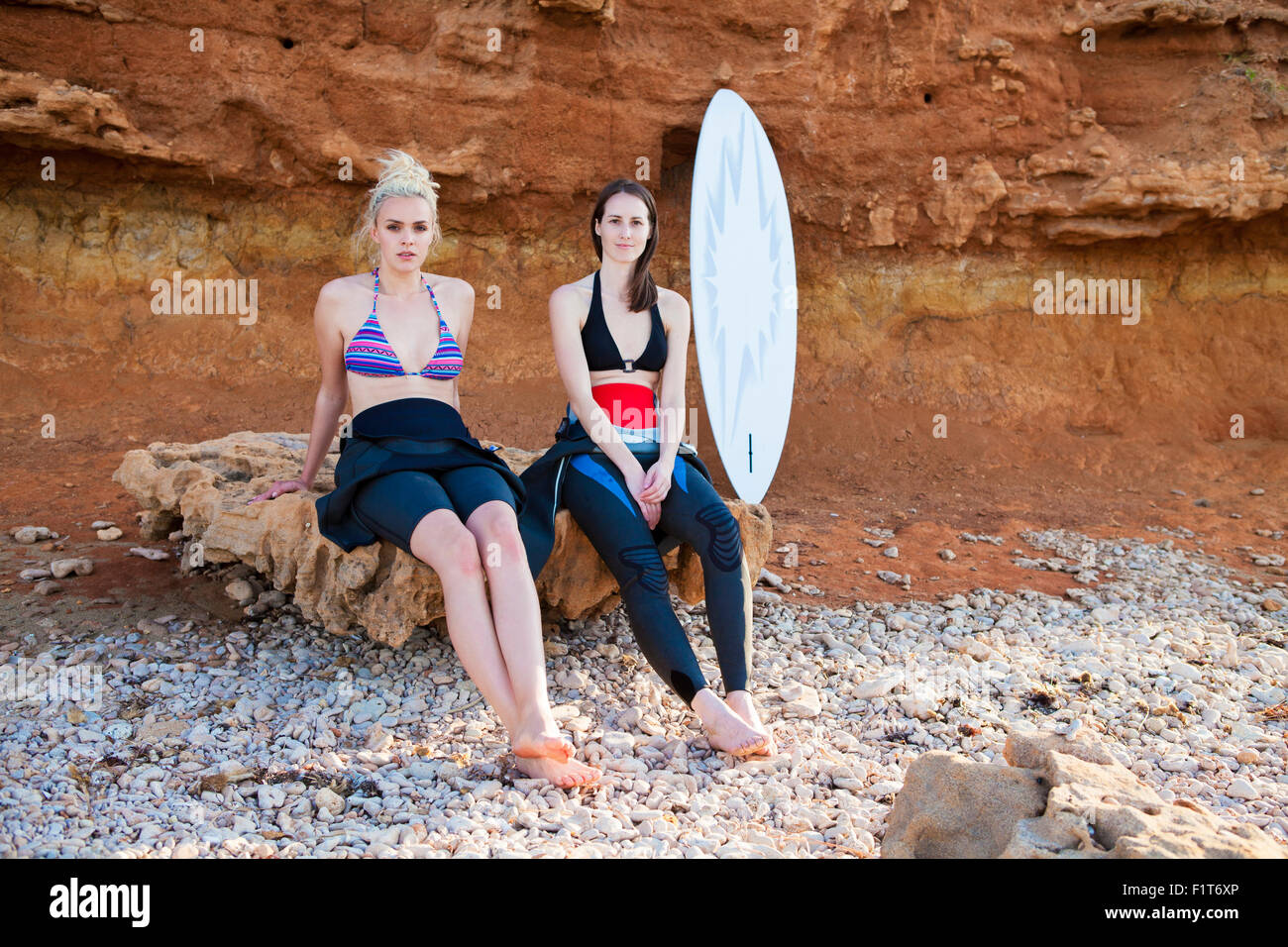 Weibliche Surfer vor rock Stockfoto