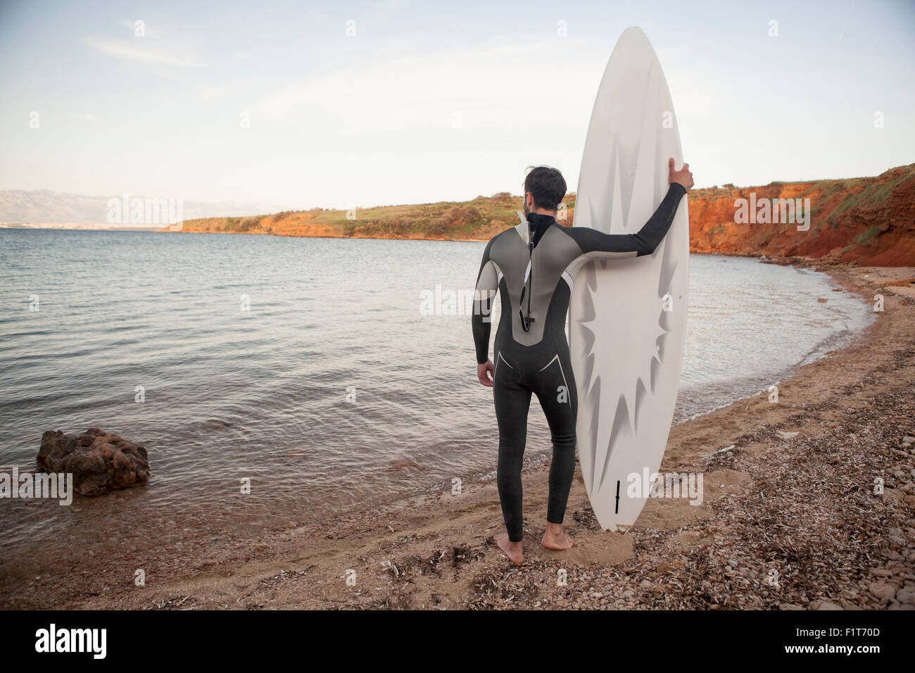 Surfer mit Surfbrett, Blick auf Meer Stockfoto