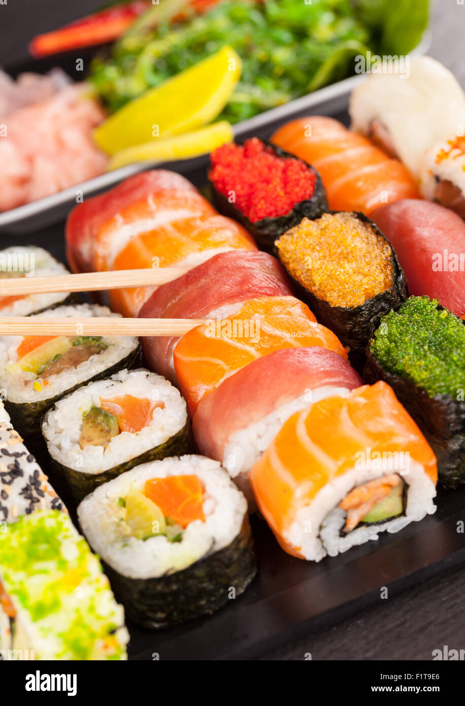 Sushi-Stücke mit Stäbchen Stockfoto