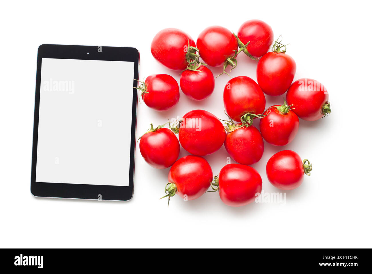 Tablet-Computer und Tomaten auf weißem Hintergrund Stockfoto