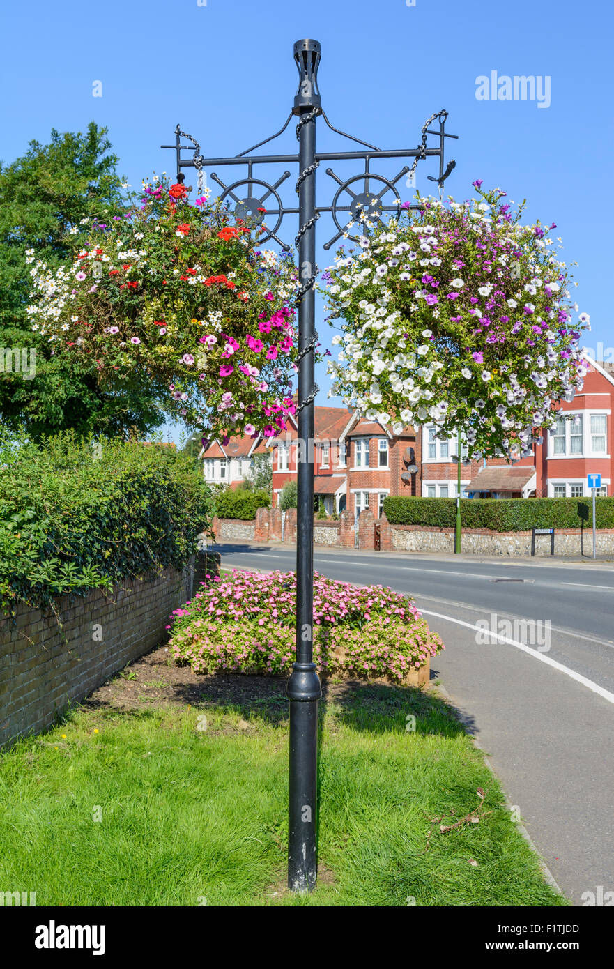 Hängende Körbe mit Blumen von der Seite einer Straße im Sommer in West Sussex, England, UK. Stockfoto