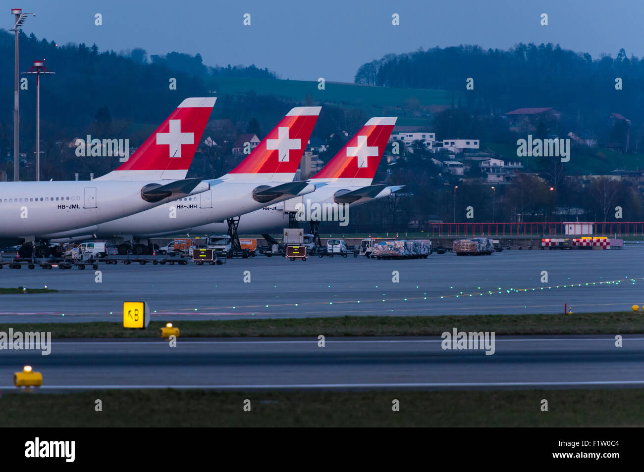 Drei Airbus A340 Langstrecken-Flugzeuge der Swiss International Air Lines sind am internationalen Flughafen Zürich für die Nacht geparkt. Stockfoto