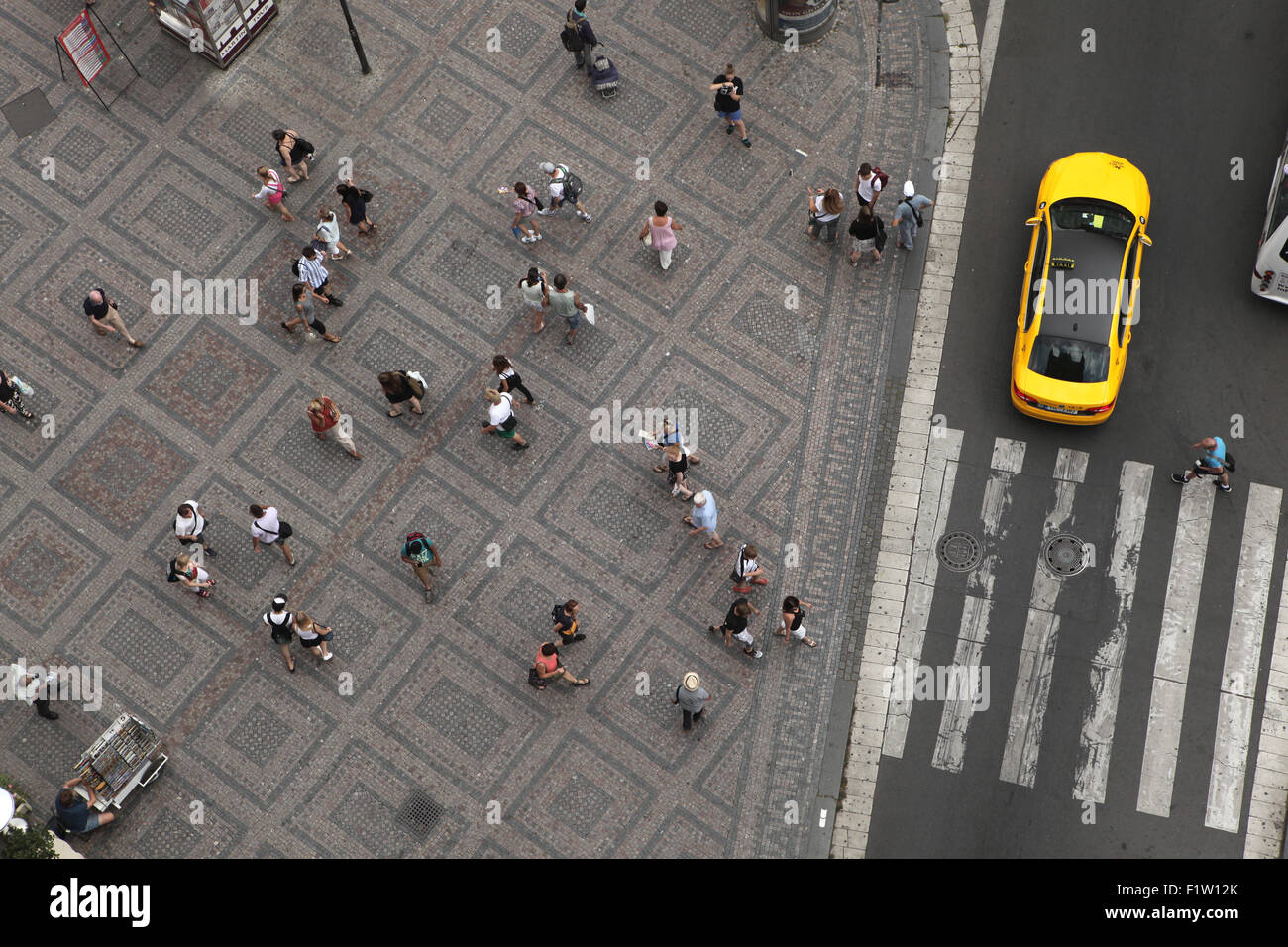Luftaufnahme von Menschen zu Fuß neben den Zebrastreifen, während ein Taxi es am Platz der Republik in Prag, Tschechische Republik soeben Stockfoto