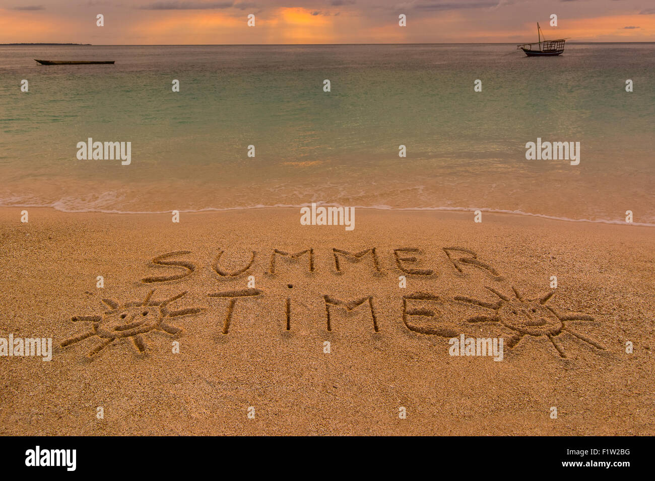 Auf dem Bild einen Strand bei Sonnenuntergang mit den Worten auf dem Sand "Sommerzeit". Stockfoto