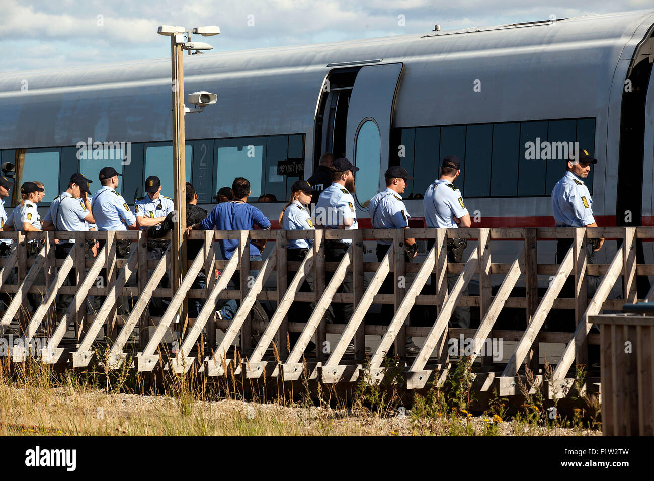 Roedby, Dänemark, August7th., 2015. Polizei umgibt einen Zug aus Deutschland kommen in den dänischen Hafen Roedby und Flüchtlinge führt sie zu den Bussen für die weitere Registrierung suchen. Die Flüchtlinge aber will vor allem nach Schweden fahren, die Asyl suchen. Bildnachweis: OJPHOTOS/Alamy Live-Nachrichten Stockfoto