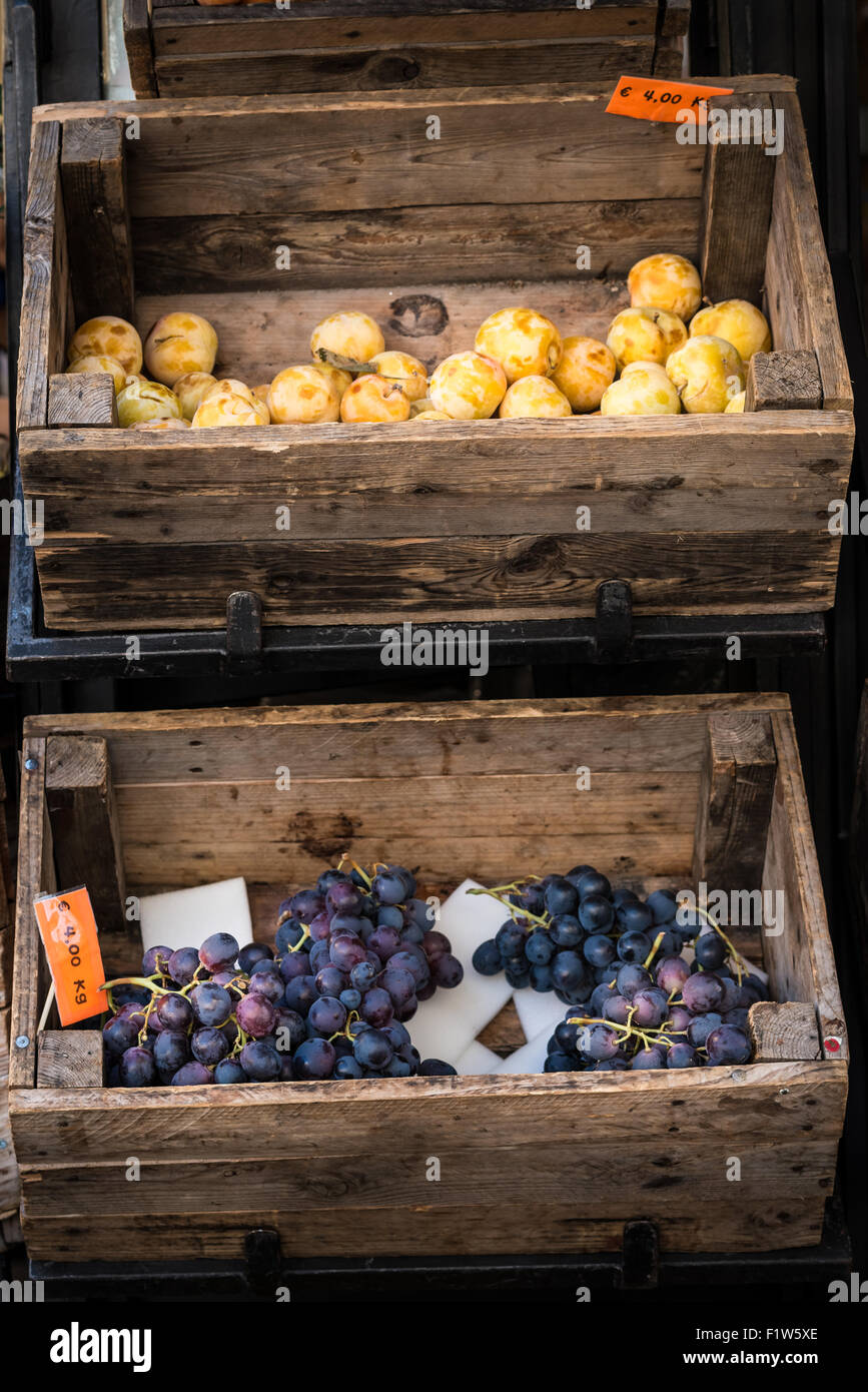 In dem Foto zwei alte Holzkisten mit in der Frucht (Trauben und Pflaumen) Stockfoto