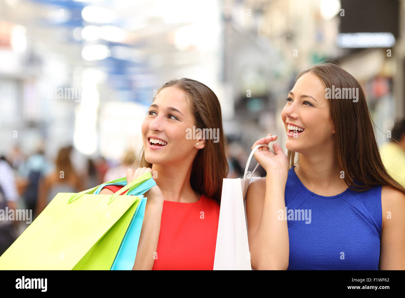Zwei Freunde in einem Einkaufszentrum kaufen und halten bunte Einkaufstaschen Stockfoto