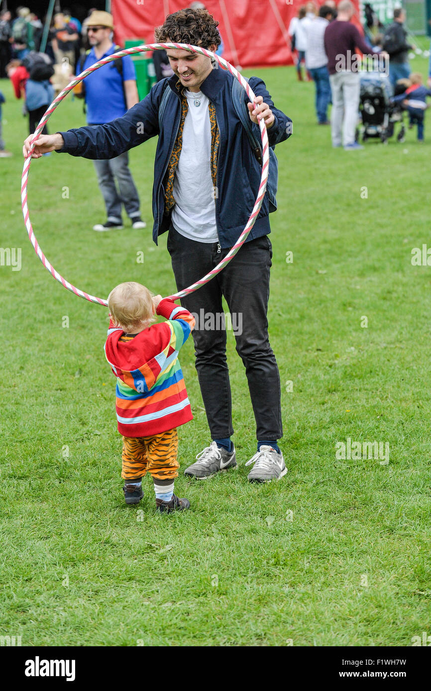 Ein Kleinkind spielen mit einem Hula-Hoop an die Menschen zusammen Festival in Brighton. Stockfoto