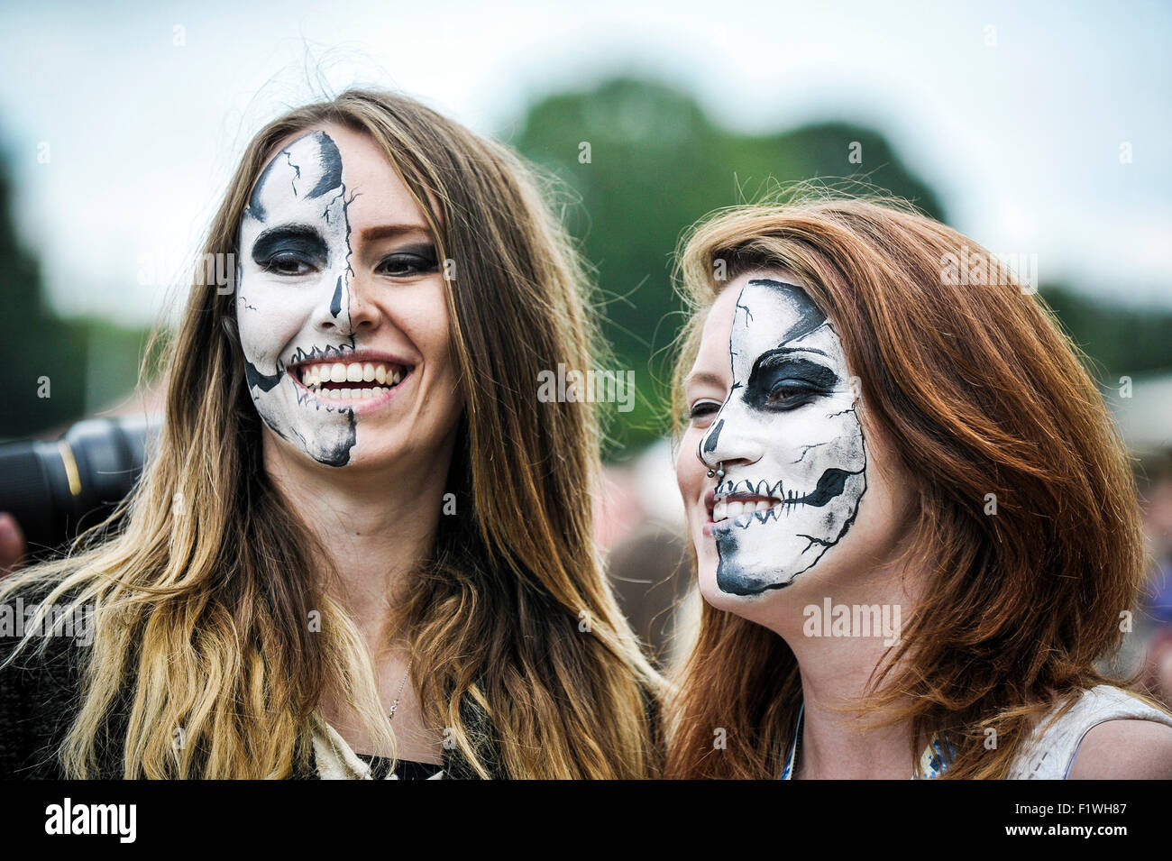 Zwei BesucherInnen mit aufgemalten Gesichtern auf miteinander der Menschen-Festival in Brighton. Stockfoto