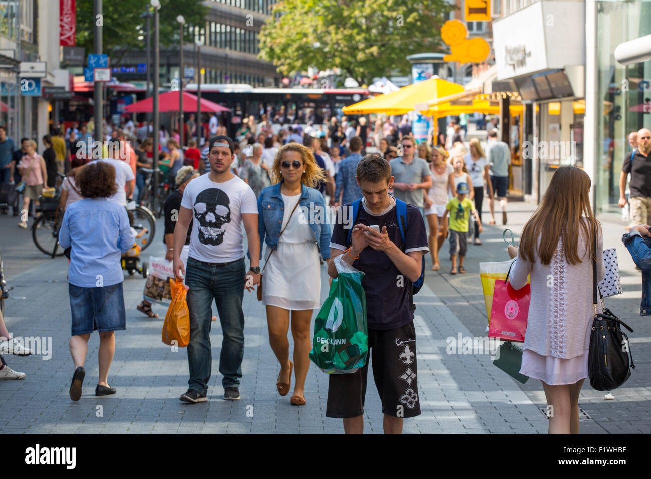 Junger Mann, die Aufmerksamkeit bei der social-Media auf seine mobile smart Phone in einer Einkaufsstraße in Deutschland Stockfoto