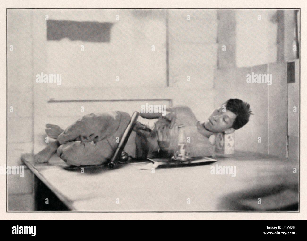 Opium Raucher Vorbereitung seiner "Opium-Pille" in einem British North Borneo Company genehmigt Opiumhöhle in Sandakan, Borneo ca. 1920. Siehe Beschreibung für mehr Informationen. Stockfoto