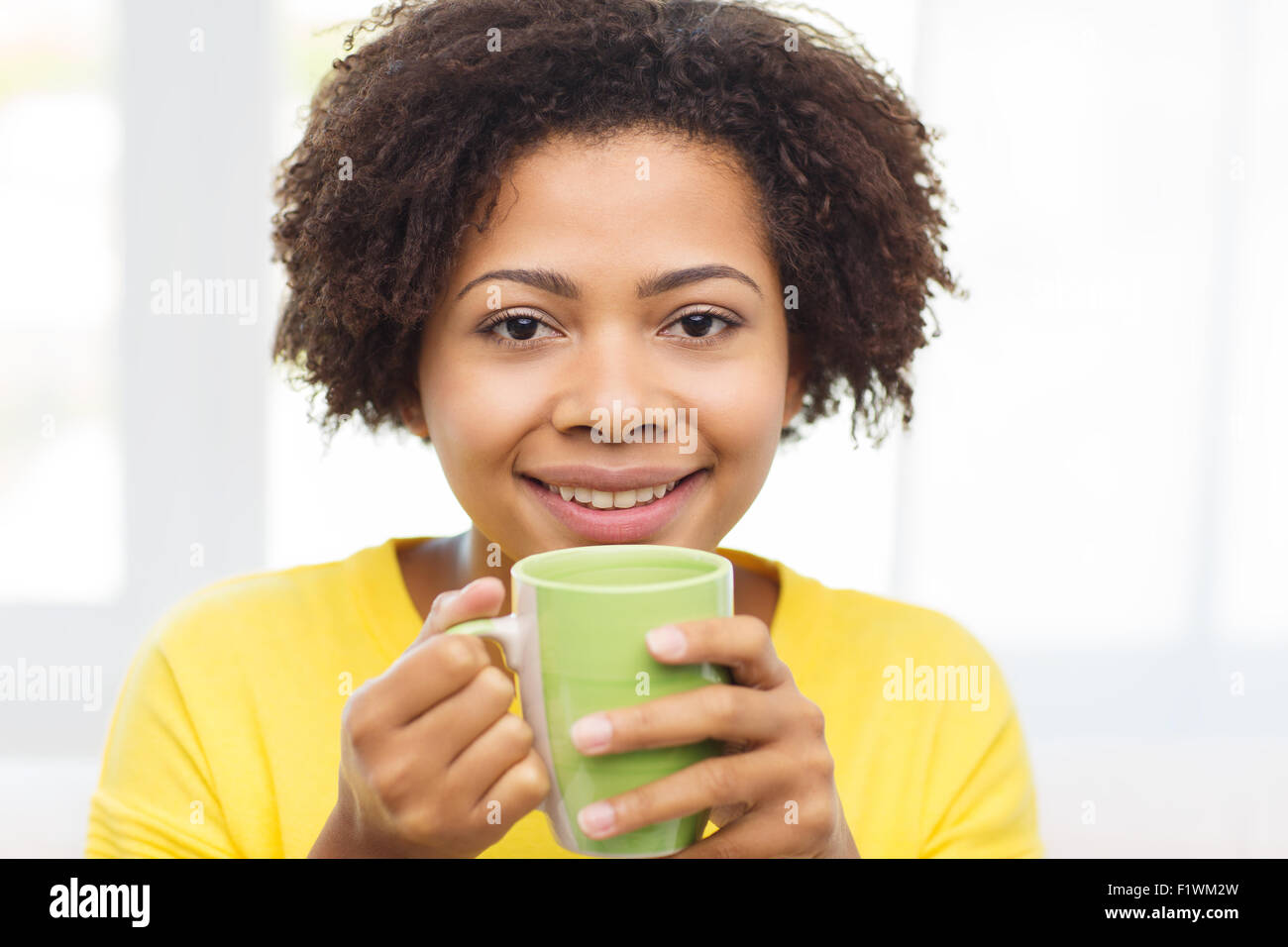 glückliche afroamerikanische Frau aus Teetasse trinken Stockfoto