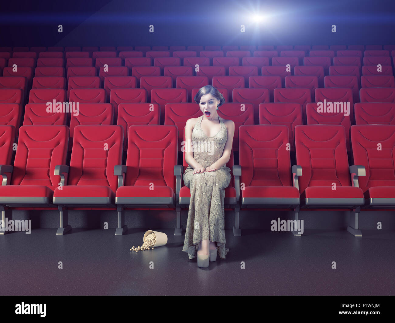 Schönes Mädchen in einem leeren Kino überrascht. Kreativkonzept Stockfoto