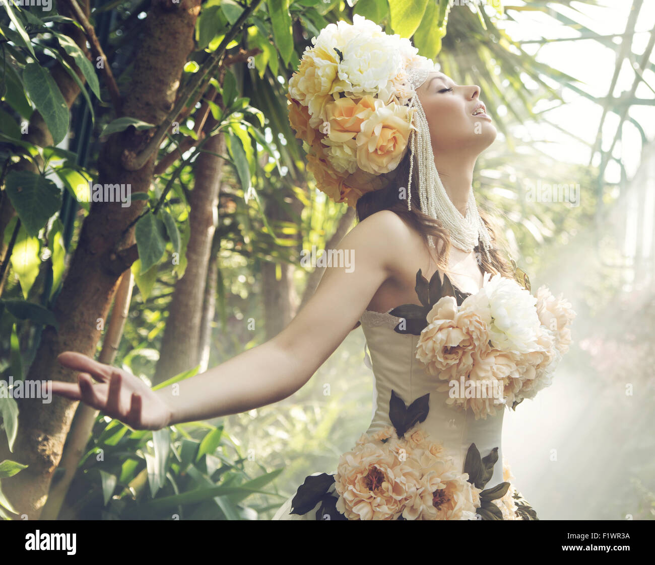 Hübsche junge Frau mit den bunten Blumenhut Stockfoto
