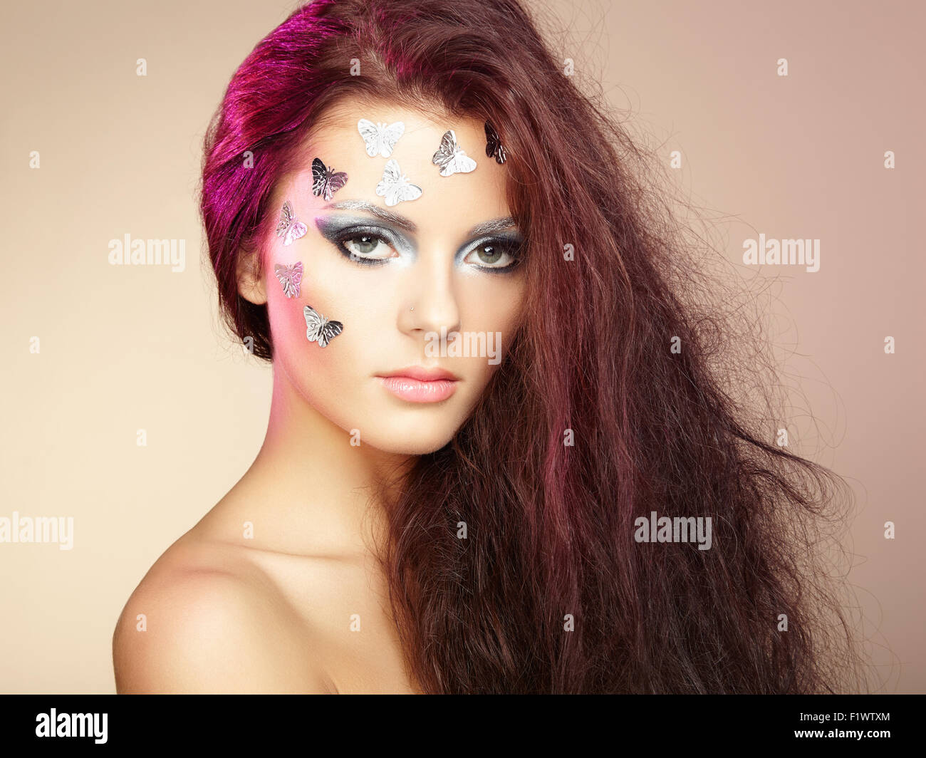 Porträt schöne junge Frau mit fliegenden Haaren. Make-up mit Schmetterlingen Stockfoto