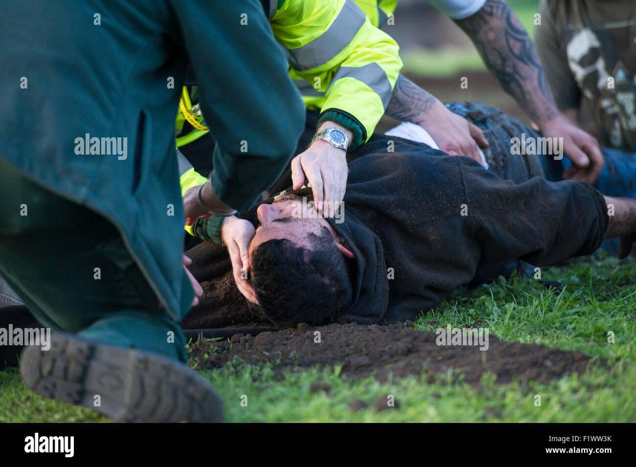 Mann bewusstlos mit Sanitäter nach dem Versuch zu entkommen, eine Standardgröße Grab Stockfoto